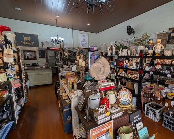 Nostalgic store interior with various collectibles and decor items on shelves.slider_item_qVpjjj